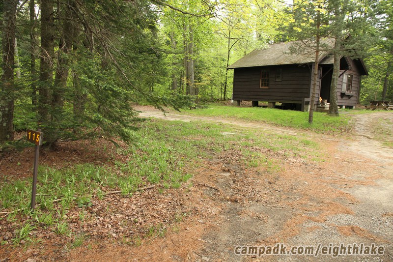Campsite Photo of Site 115 at Eighth Lake Campground, New York - Looking at Site from Road Sign Visible