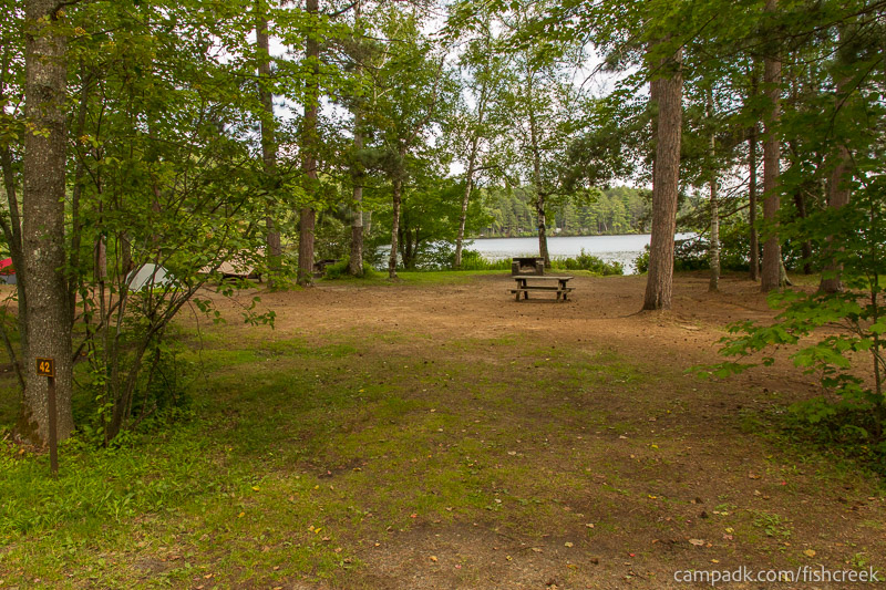 Campsite Photo of Site 52 at Fish Creek Pond Campground, New York - Looking at Site from Road Sign Visible