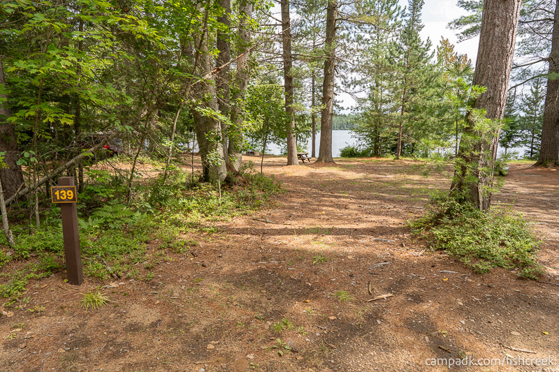 Campsite Photo of Site 169 at Fish Creek Pond Campground, New York - Looking at Site from Road Sign Visible