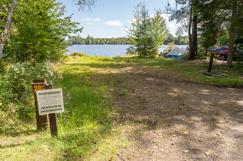 Campsite Photo of Site 310 at Fish Creek Pond Campground, New York - Looking at Site from Road Sign Visible