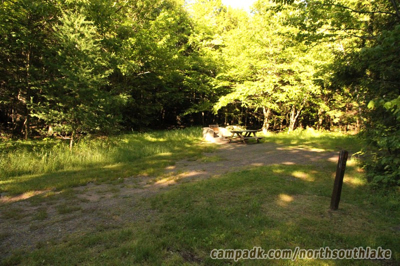 Campsite Photo of Site 100 at North South Lake Campground, New York - Looking at Site from Road Sign Visible