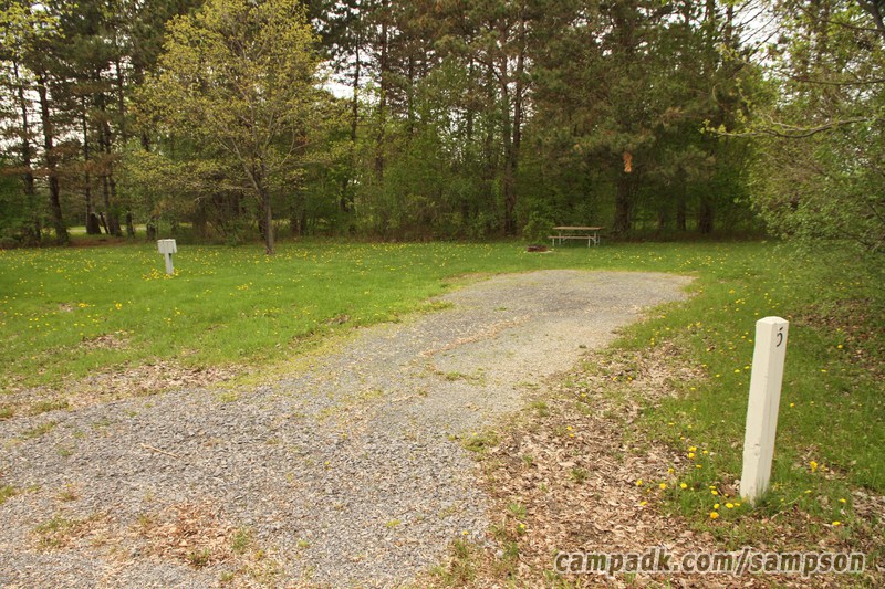 Campsite Photo of Site 5 at Sampson State Park, New York - Looking at Site from Road Sign Visible