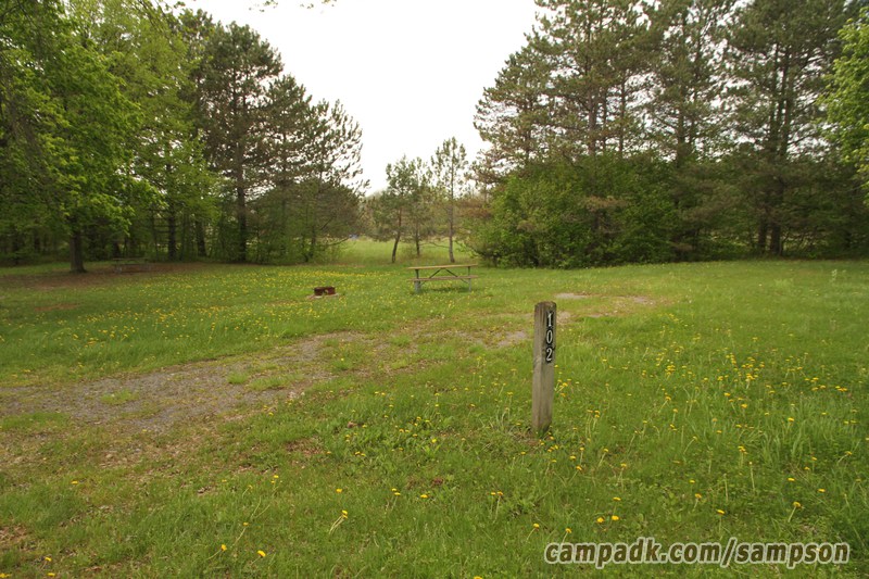 Campsite Photo of Site 102 at Sampson State Park, New York - Looking at Site from Road Sign Visible